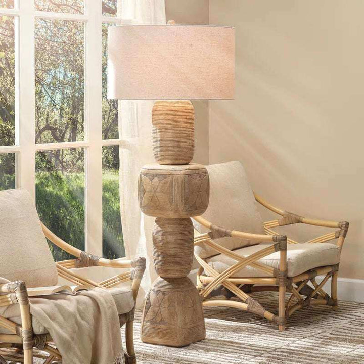 Totem 62'' Traditional Floor Lamp featuring carved mango wood base and natural linen shade in a bright living room setting.